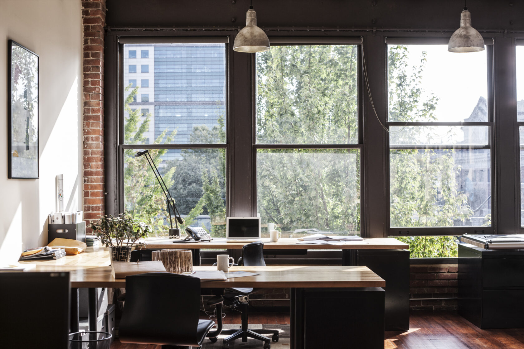 Creative office interior. View through a window to trees and city buildings.