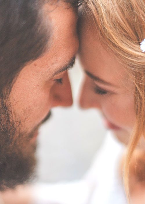 Close-up of a man and woman with foreheads touching, conveying deep affection and connection.