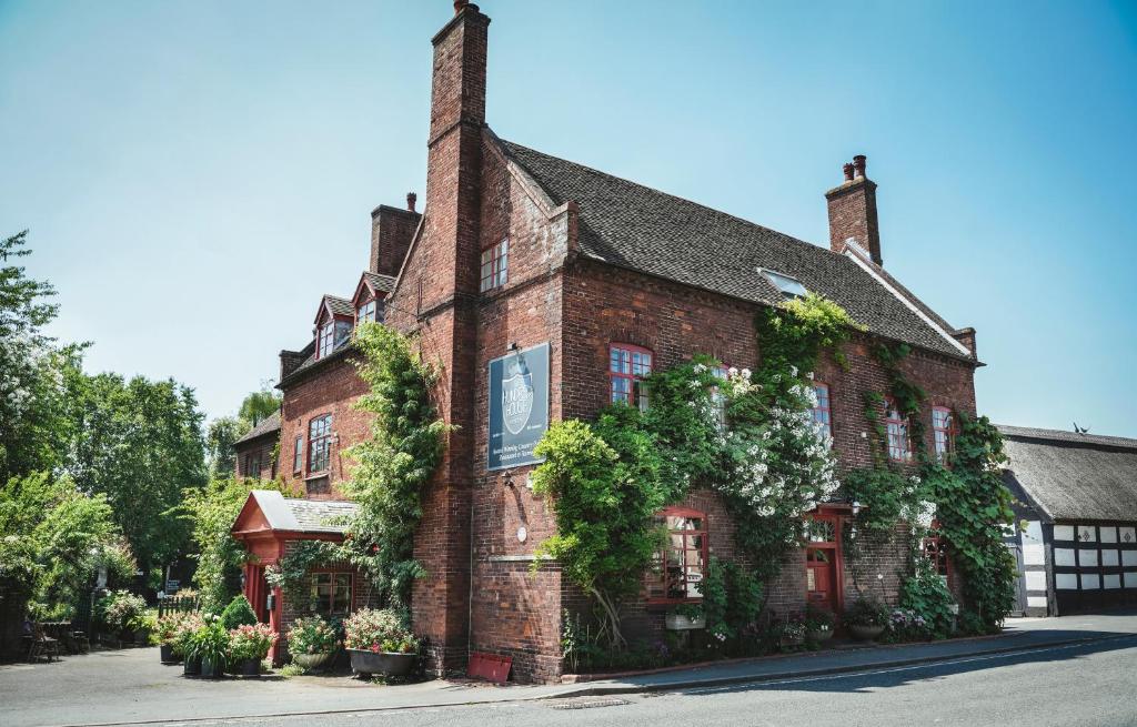 A picturesque brick building adorned with climbing plants, set against a clear blue sky.